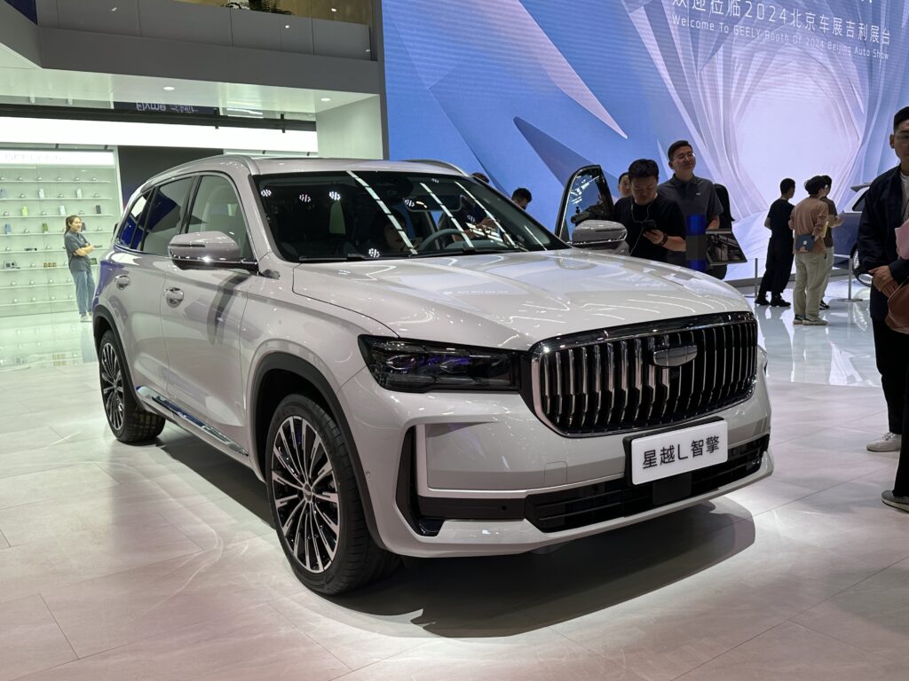 Белый гибридный кроссовер Geely Xingyue L Zhiqing на автосалоне